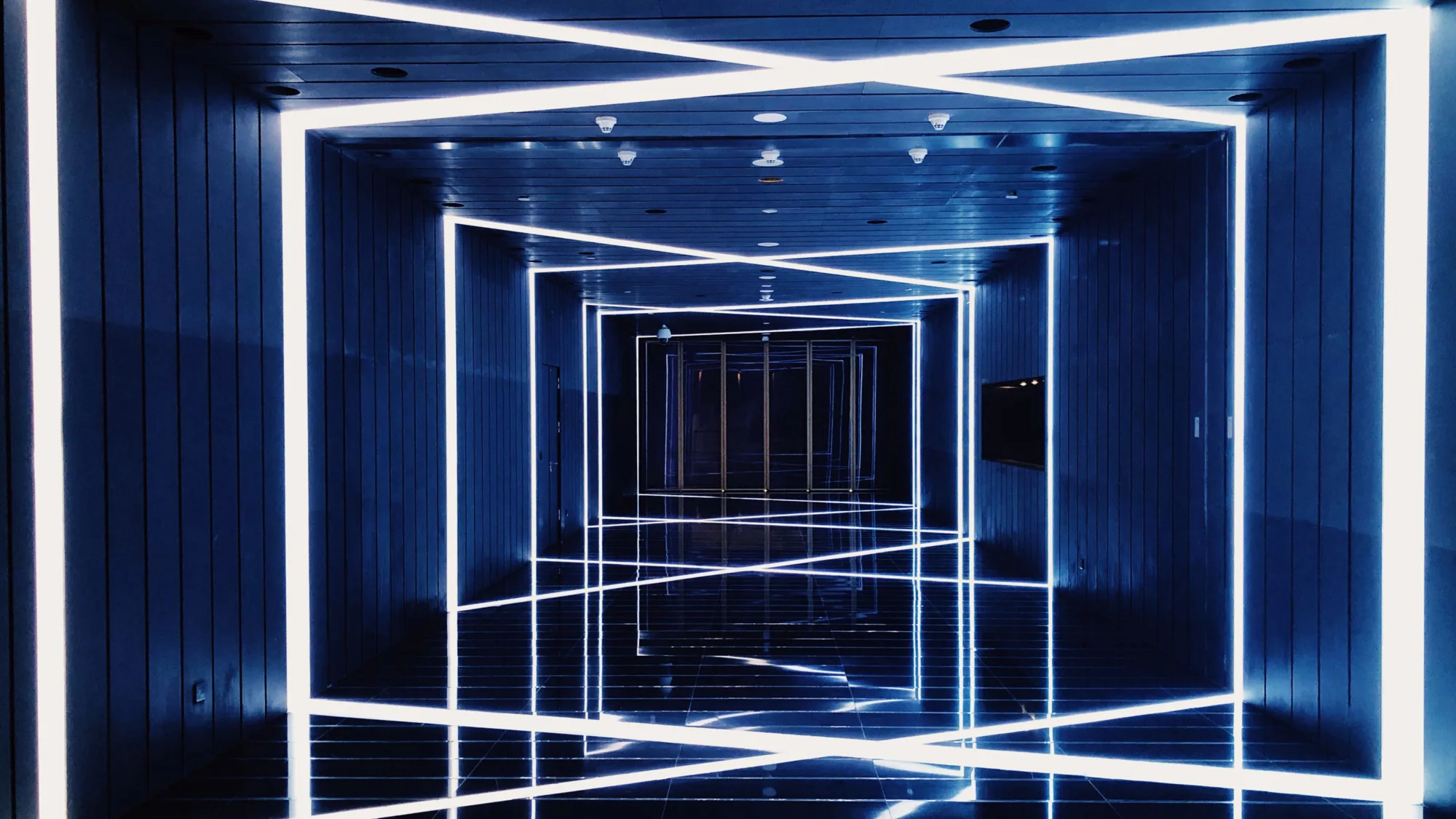 Dark corridor with crossing neon strip lights