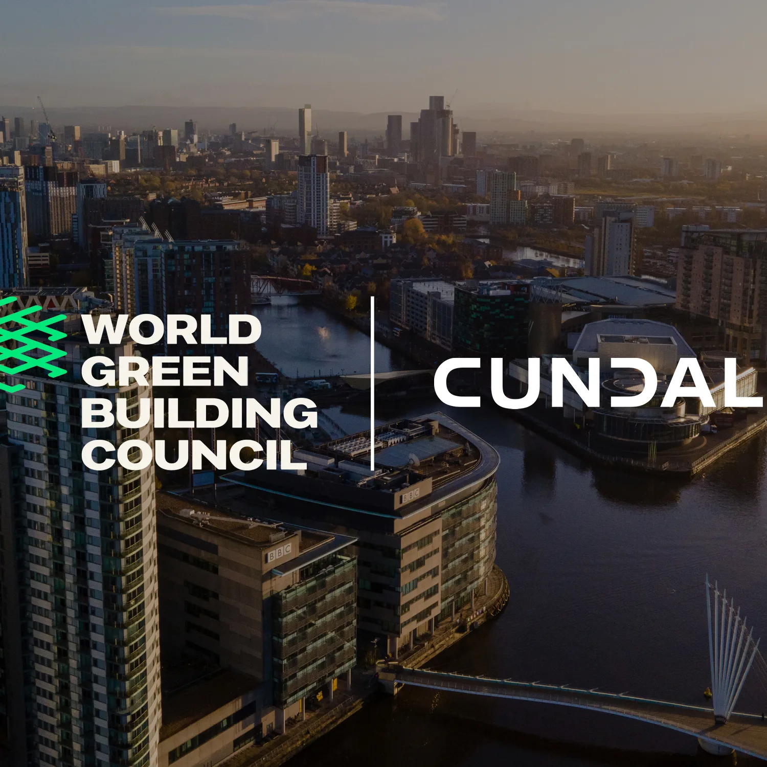Aerial view of a modern cityscape with high-rise buildings along a river, bridges crossing the water, and urban streets. The image includes two logos: “World Green Building Council” in white and green on the left and “Cundall” in white on the right, positioned over the city background.